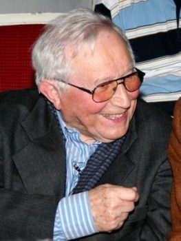 zdjęcie pokazujące mężczyznę uśmiechniętego w garniturze - Tadeusza Różewicza