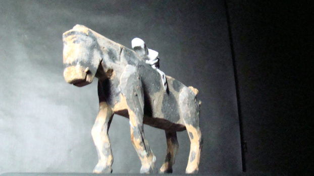 łaciaty koń z modeliny, z siedzącym na grzbiecie zakapturzonym jeźdźcem