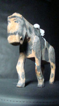 łaciaty koń z modeliny, z siedzącym na grzbiecie zakapturzonym jeźdźcem