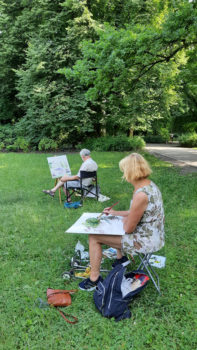 kobieta maluje  z natury pejzaż w parku 