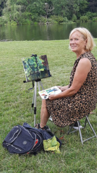 kobieta maluje  z natury pejzaż w parku 